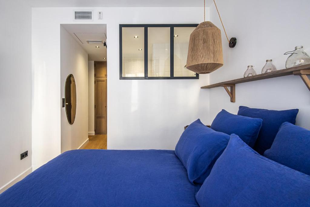 ein Schlafzimmer mit einem blauen Bett und einem Fenster in der Unterkunft Maison Volver in Arles