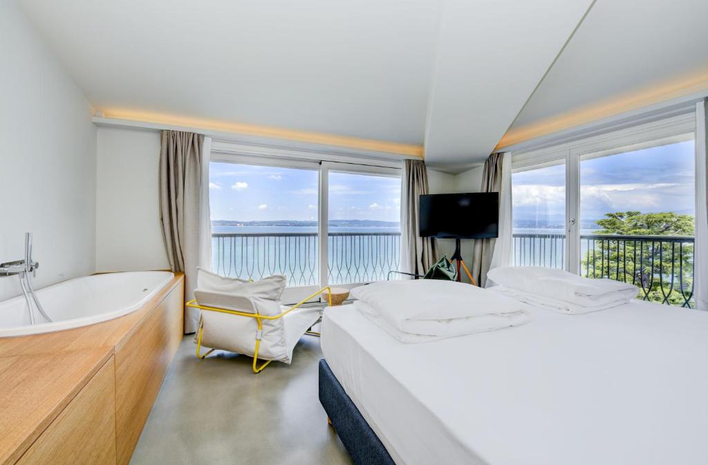 um quarto com uma banheira, uma cama, uma banheira e uma televisão em Hotel Flaminia em Sirmione