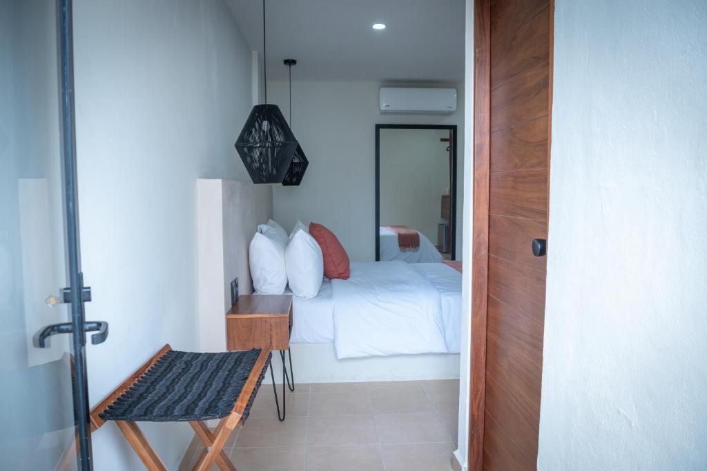 a bedroom with a bed and a table and a chair at Rodina Boutique Hotel in Playa del Carmen