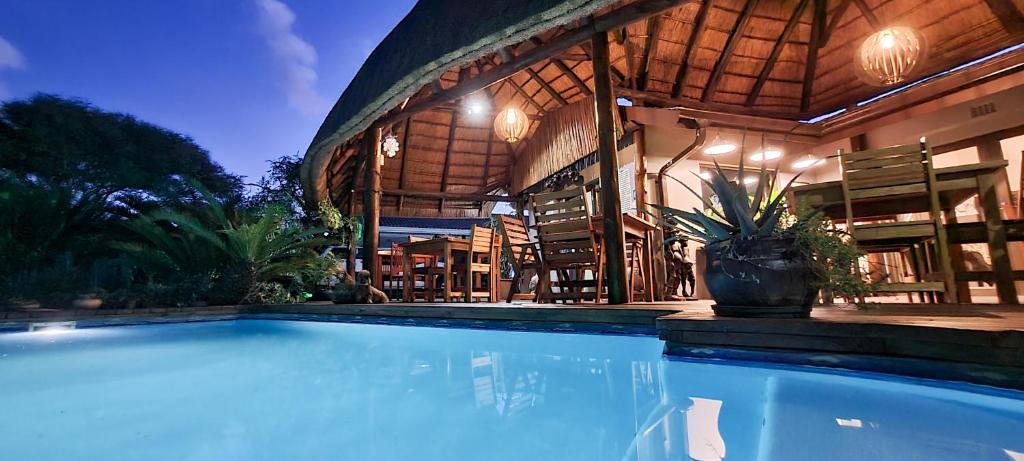 a house with a swimming pool in front of a building at Leopard Corner Lodge in St Lucia