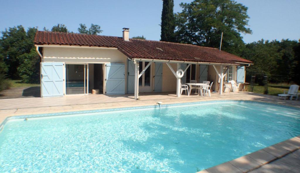 een huis met een zwembad voor een gebouw bij La petite maison du Bosc in Saint-Antonin