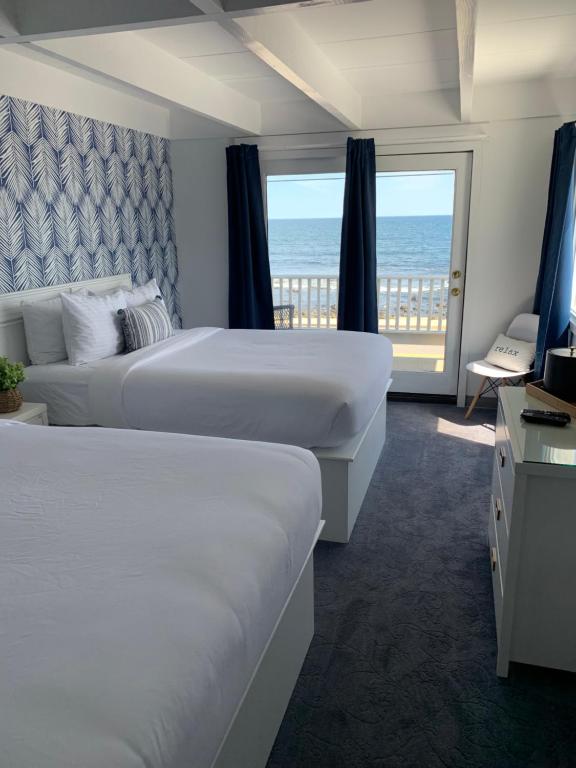 a hotel room with two beds and a view of the ocean at Grand View Hotel in York Beach