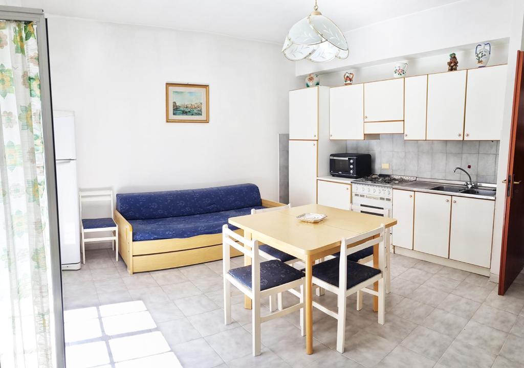 cocina pequeña con mesa y sofá azul en Appartamento Akesines, en Trappitello