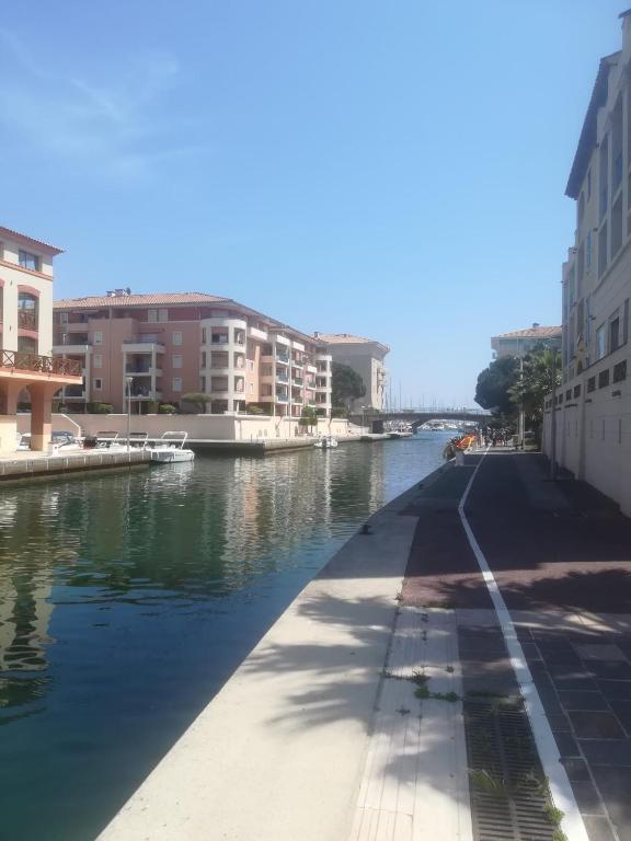 un canal dans une ville avec des bâtiments et de l'eau dans l'établissement Sur le quai de port fréjus, à Fréjus