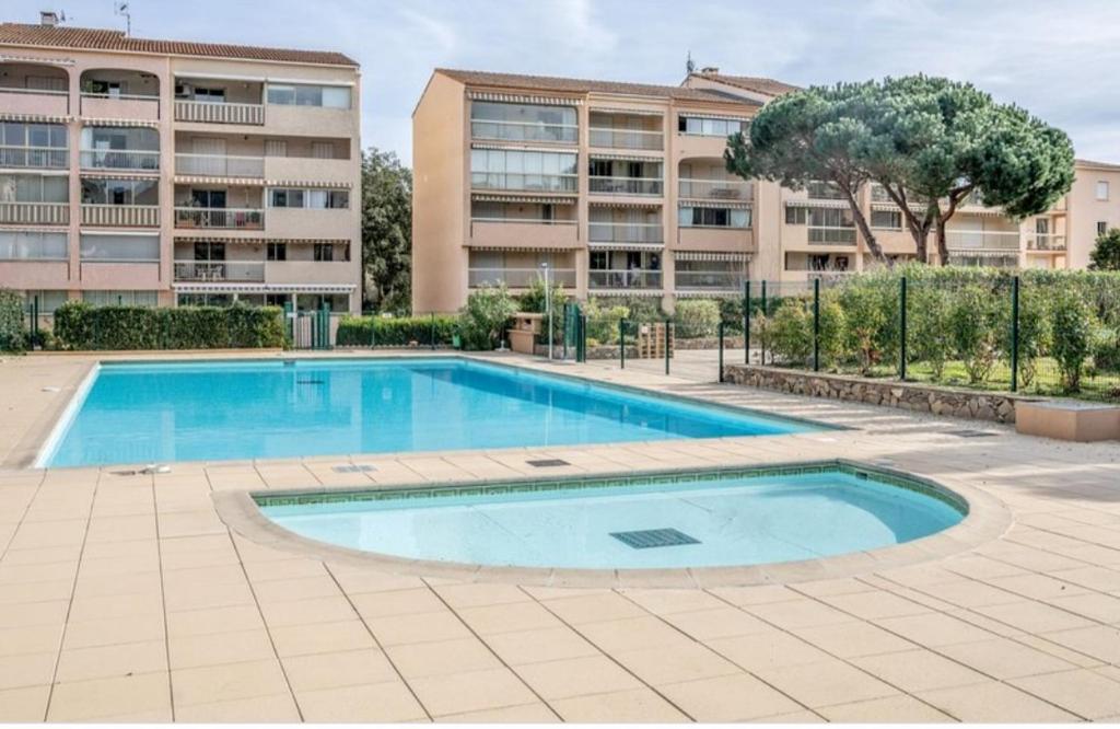 an empty swimming pool in front of a building at Appartement Ste Maxime in Sainte-Maxime