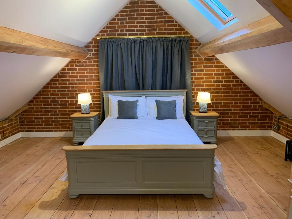 um quarto com uma cama e duas mesas de cabeceira em Unique Countryside Retreat, walking distance to the Three Choirs Vineyard & Restaurant, Gloucestershire em Newent