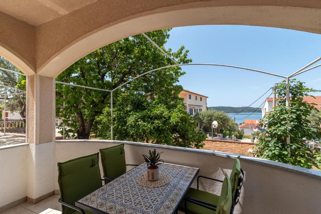 patio con mesa y sillas en el balcón en Apartments Fani, en Trogir