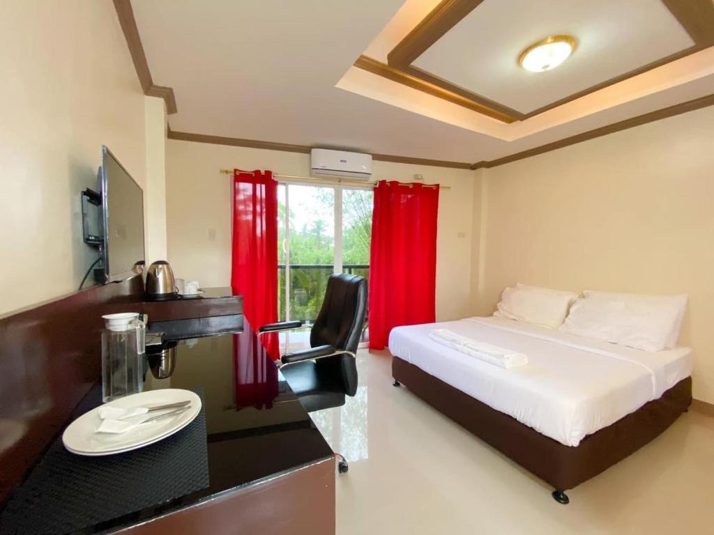 Baybay的住宿－Red Palm Inn balcony room with Netflix，一间卧室配有一张床和一张带水槽的书桌