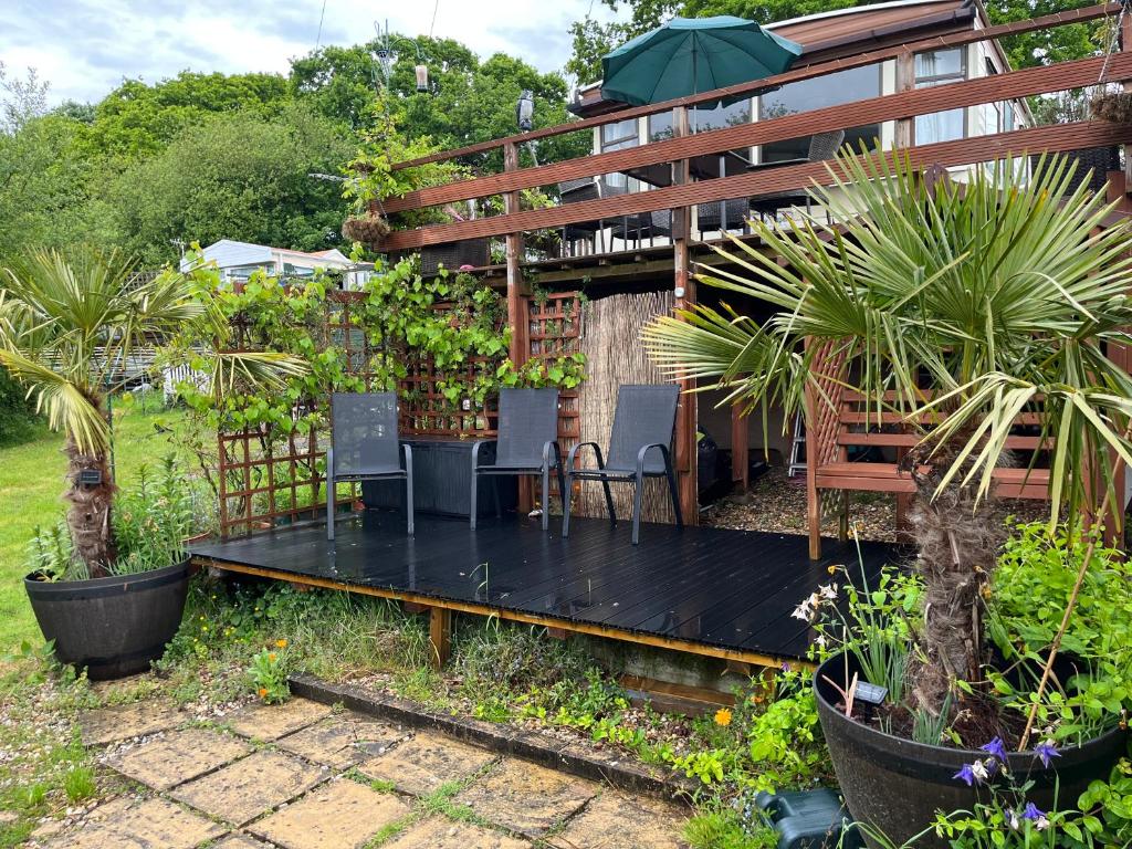 a patio with chairs and plants in front of a building at Private Holiday home in calm site in Wootton Bridge
