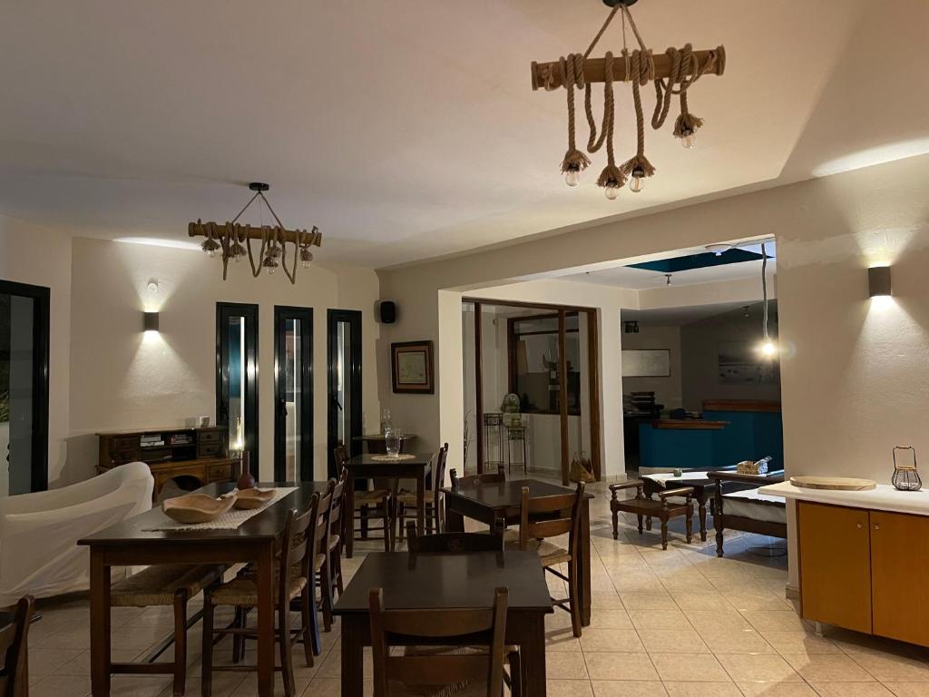 a dining room with tables and chairs and a chandelier at Nisea Hotel Samos in Pythagoreio