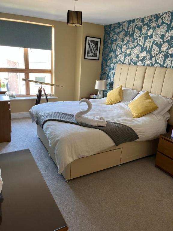 - une chambre avec un grand lit recouvert d'un cygne dans l'établissement Stunning Marina apartment Gosport Portsmouth, à Gosport