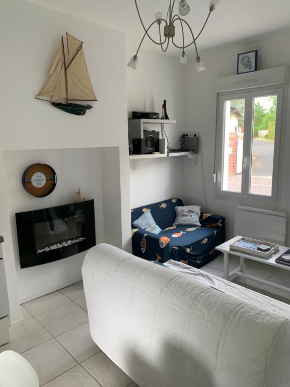 un salon avec un canapé et une cheminée dans l'établissement La Bethencouroise, à Béthencourt-sur-Mer