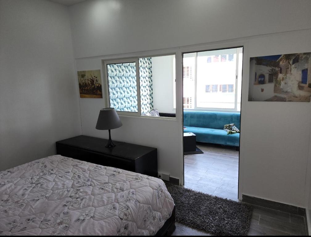 拉巴特的住宿－cosy home，一间卧室配有一张床和一张蓝色的沙发