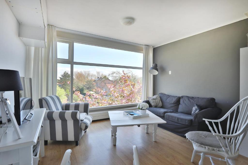 a living room with a couch and a window at Chapeau in Zandvoort