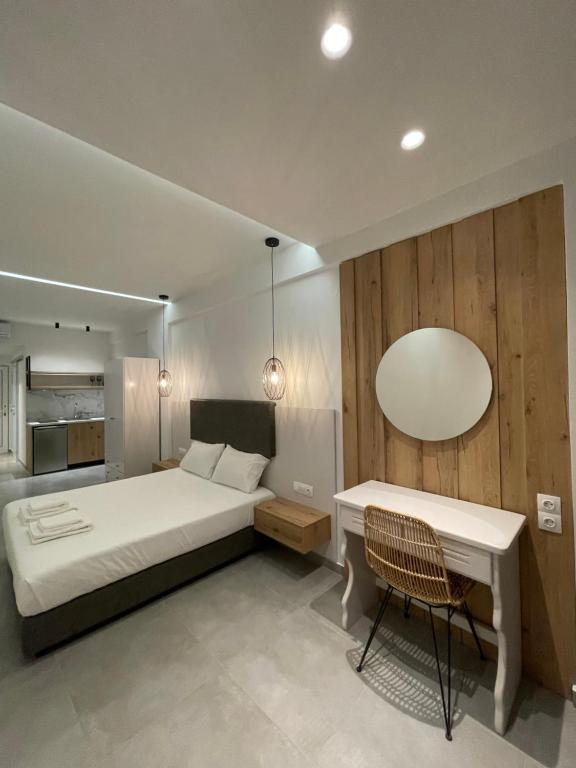 een slaapkamer met een bed, een tafel en een stoel bij George Deluxe Apartments in Stalida