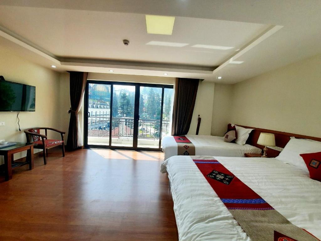 a hotel room with two beds and a large window at Sapa Star Hotel in Sapa