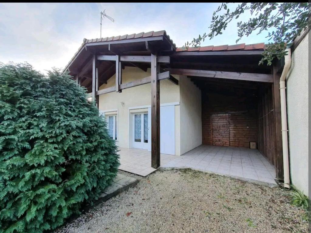 ein Haus mit einer Garage und einer Ziegelwand in der Unterkunft Maison idéalement située pour 6 personnes in Soustons