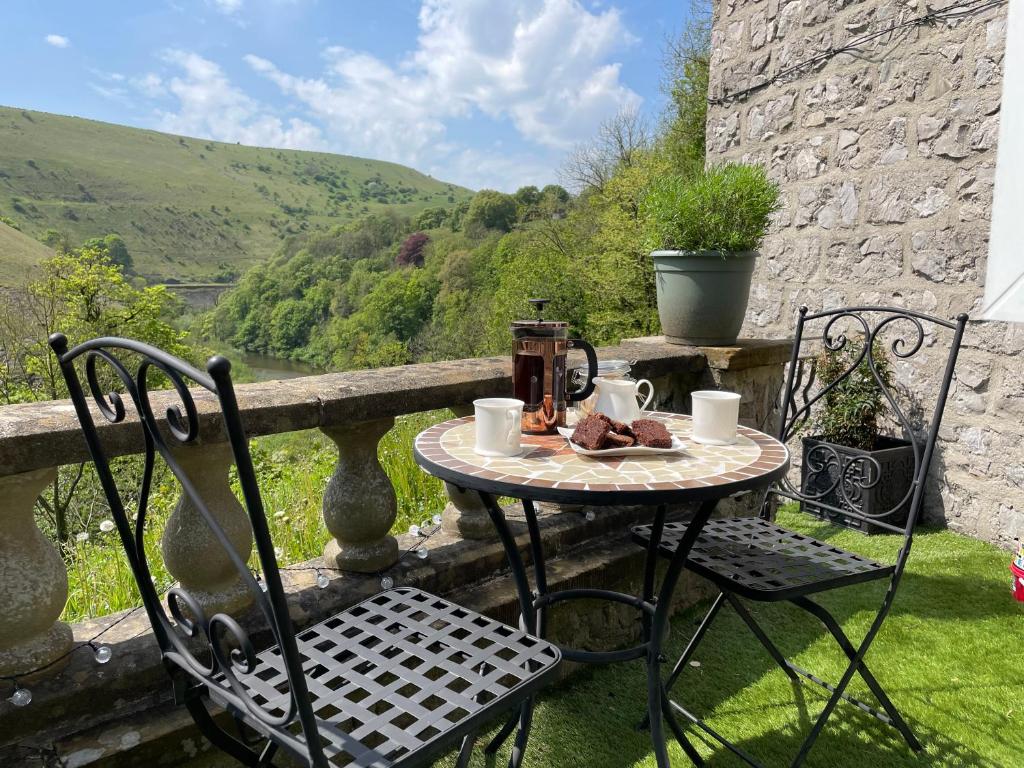 a table and chairs sitting on a balcony with a view at River View in Buxton