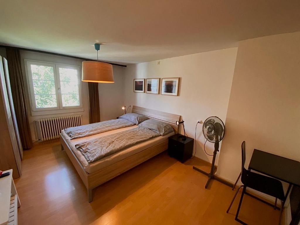 1 dormitorio con 1 cama, escritorio y ventilador en Budgetapartment Imperia von Swisspartments, en Arbon
