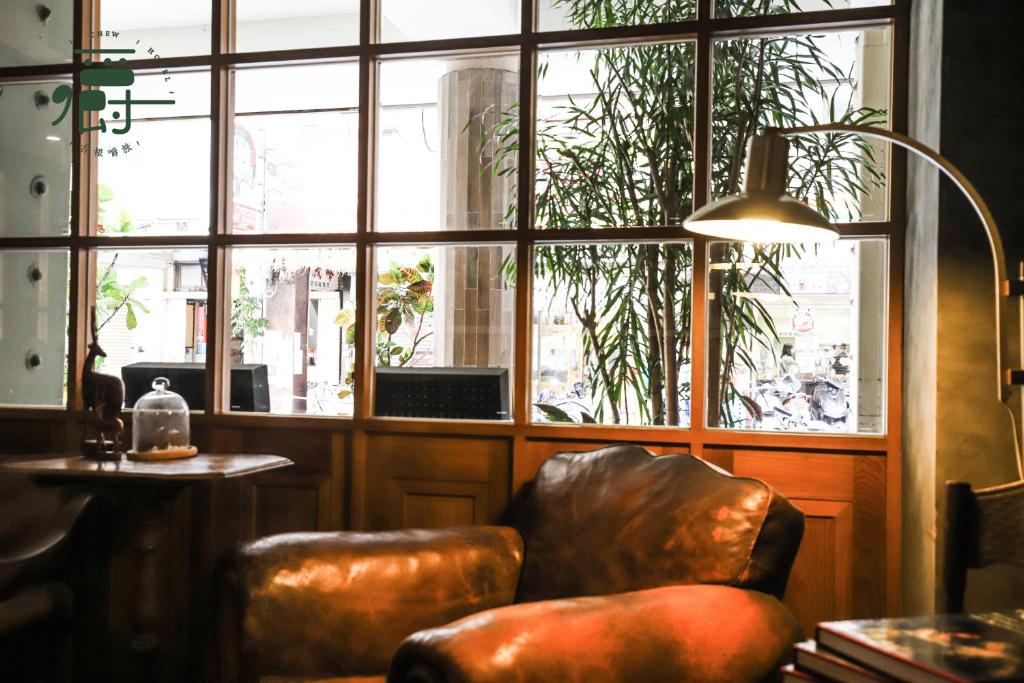 a room with a chair and a large window at Roots Chew Hotel in Tainan