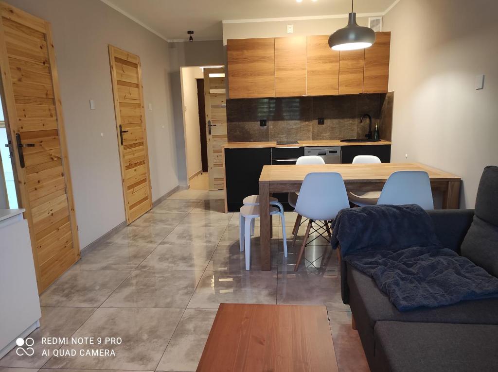 a living room and kitchen with a table and chairs at Apartament Spokojny in Mielno