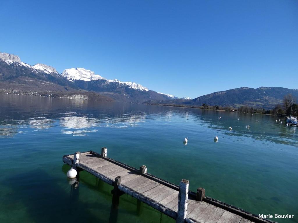 a dock on a lake with mountains in the background at La Madeleine in Annecy