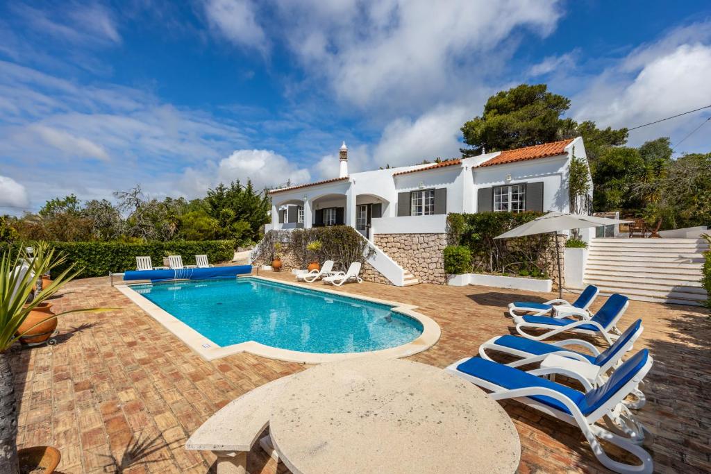 a villa with a swimming pool and a house at CoolHouses Algarve Lagos, 4 bed single-story House, pool and amazing panoramic views, Casa Fernanda in Lagos