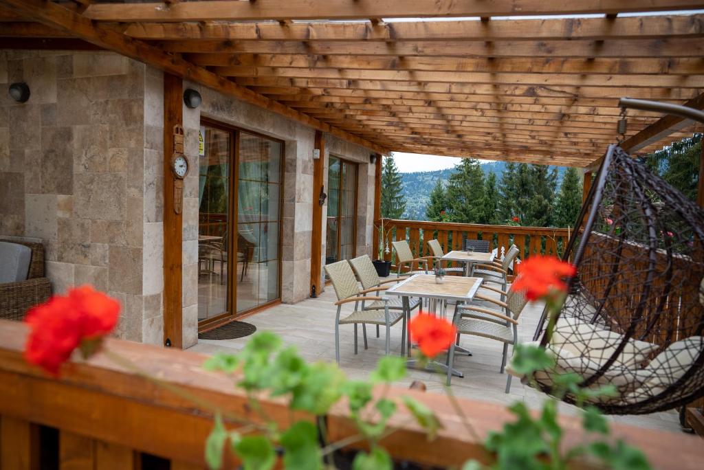 eine Terrasse mit einem Tisch und Stühlen auf einer Terrasse in der Unterkunft Poiana Brazilor in Borşa