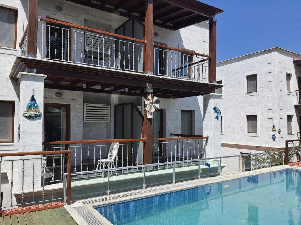 a building with a balcony and a swimming pool at Stone House Hotel in Bodrum City