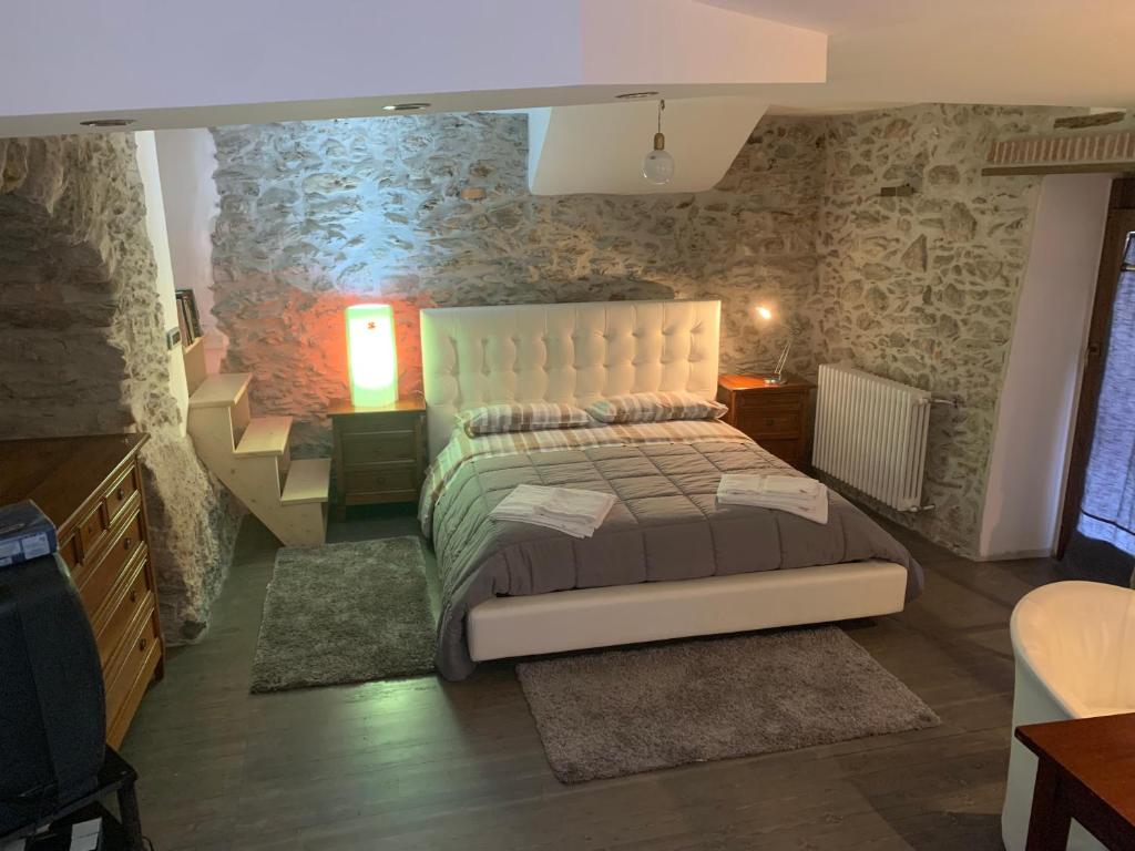 a bedroom with a bed and a stone wall at Bed & Breakfast StudioArcodia in San Marco dʼAlunzio