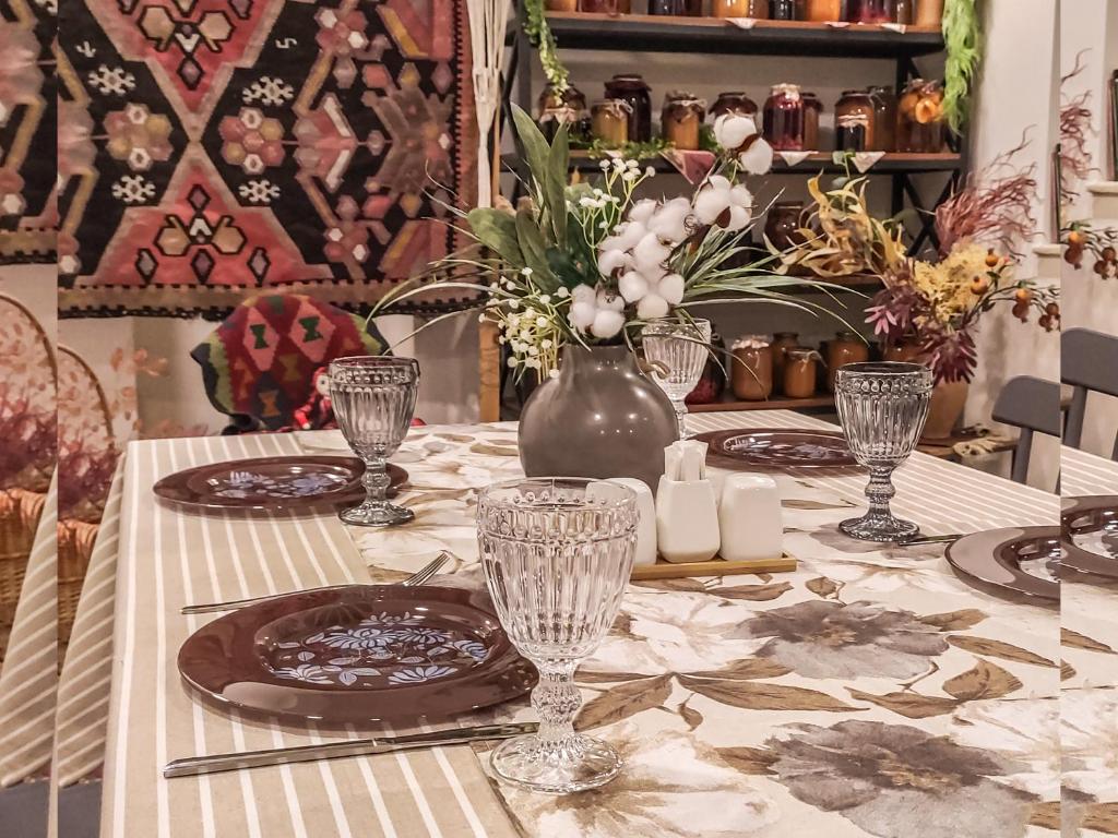 a table with a table cloth with a vase of flowers at Harmonia Garden Hotel&Restaurant in Garni