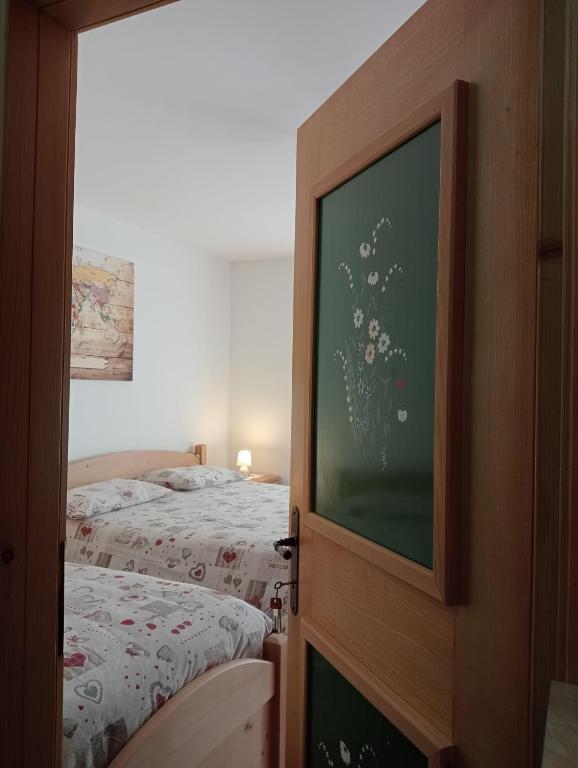 sypialnia z 2 łóżkami i telewizorem z płaskim ekranem w obiekcie B&B Il Tulipano w mieście San Pietro di Cadore