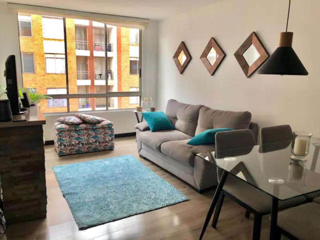 uma sala de estar com um sofá e uma mesa de vidro em Fantástica Habitación Privada Colina em Bogotá