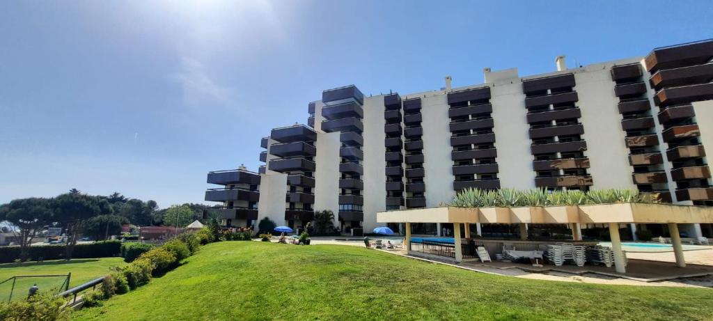 a large apartment building with a park in front of it at Cascais By the Sea in Cascais