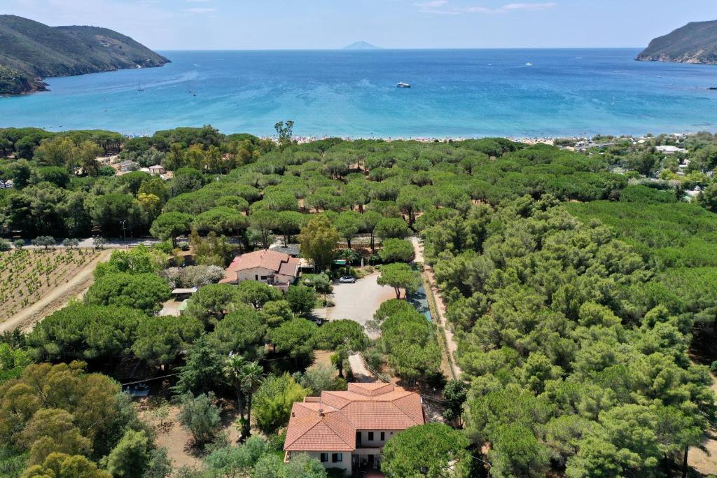 una vista aerea di una casa con alberi e oceano di Hotel Giardino a Capoliveri