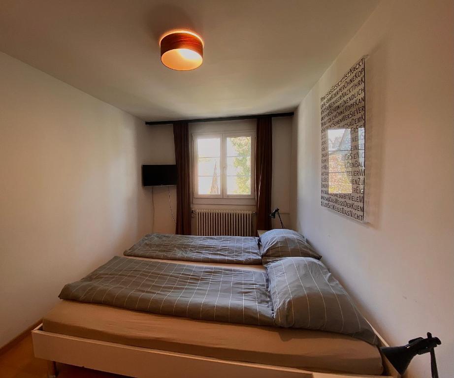 1 cama en un dormitorio con ventana en Budgetapartment Martinsturm von Swisspartments, en Arbon