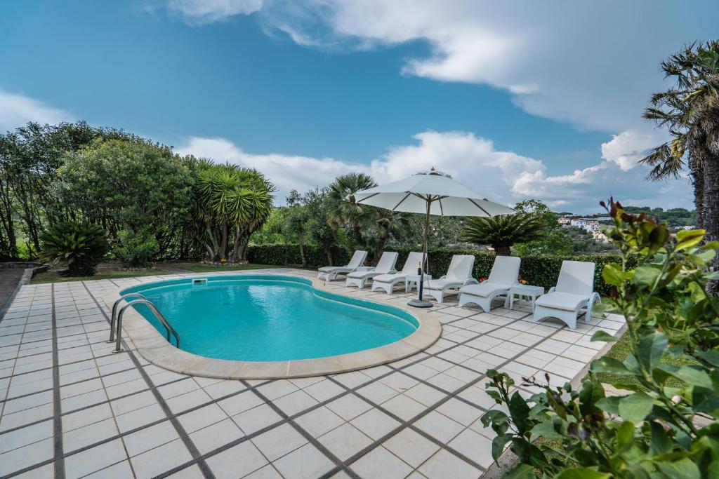 圣安吉洛Villa La Pace的带躺椅和遮阳伞的游泳池
