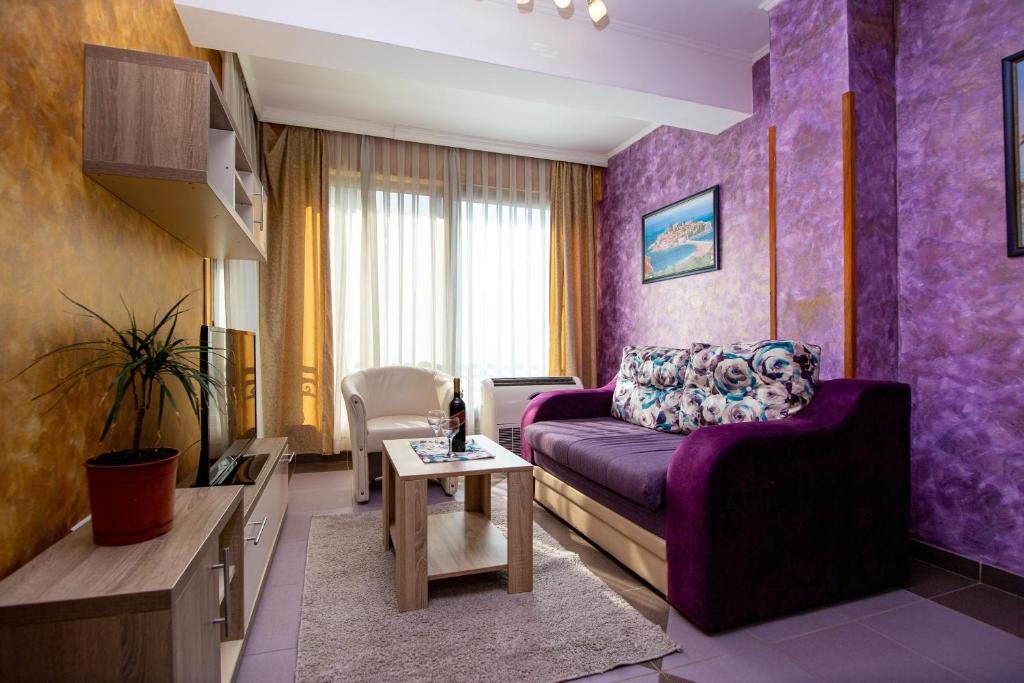 a purple living room with a purple couch and a table at SunSea Apartments in Budva