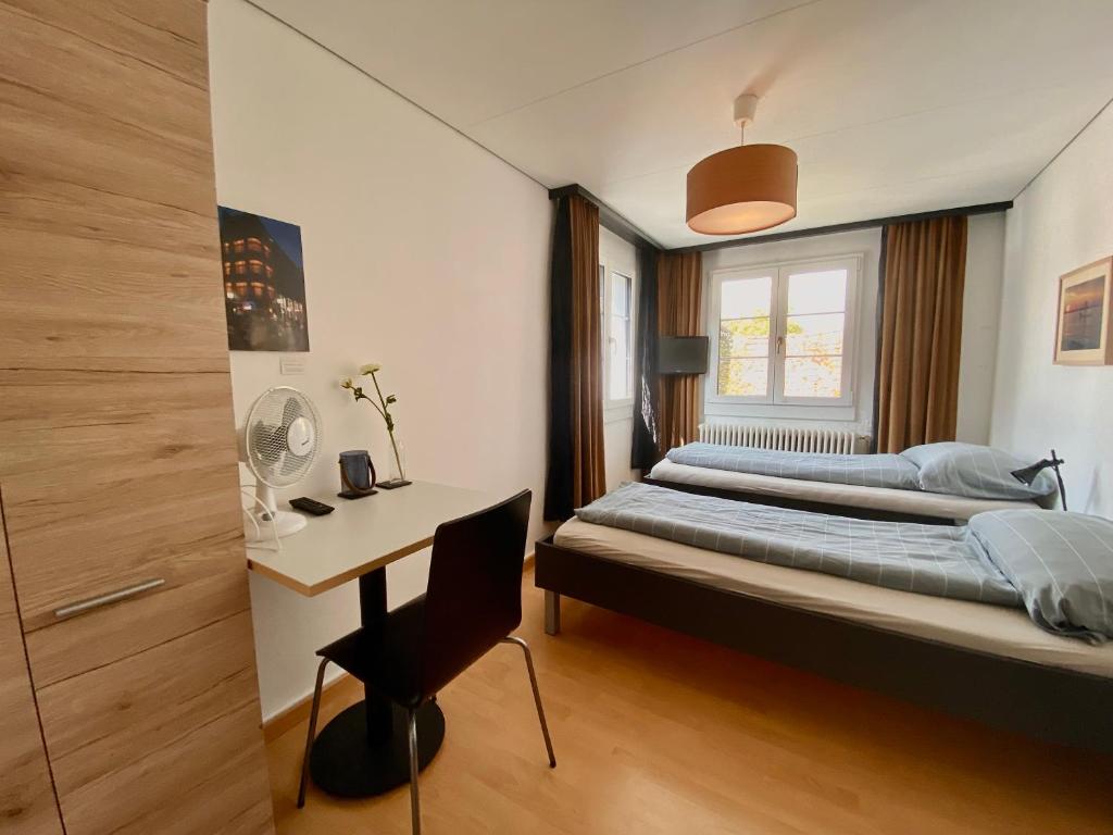a bedroom with two beds and a desk in it at Budgetapartment Seealpsee von Swisspartments in Arbon