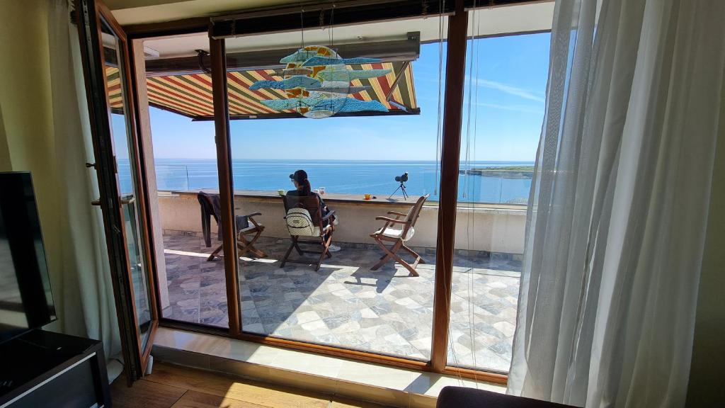a room with a view of the ocean from a balcony at Magic Sea View in Tsarevo