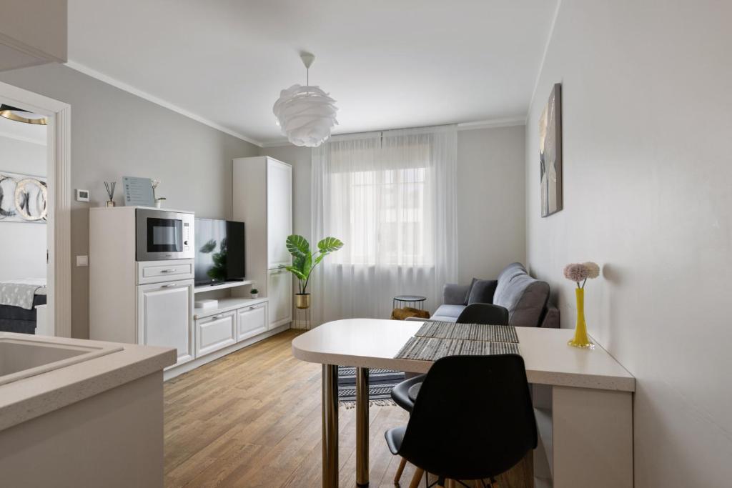 a kitchen and living room with a table and chairs at Brand new, cozy downtown apartment near airport and bus station. in Tallinn