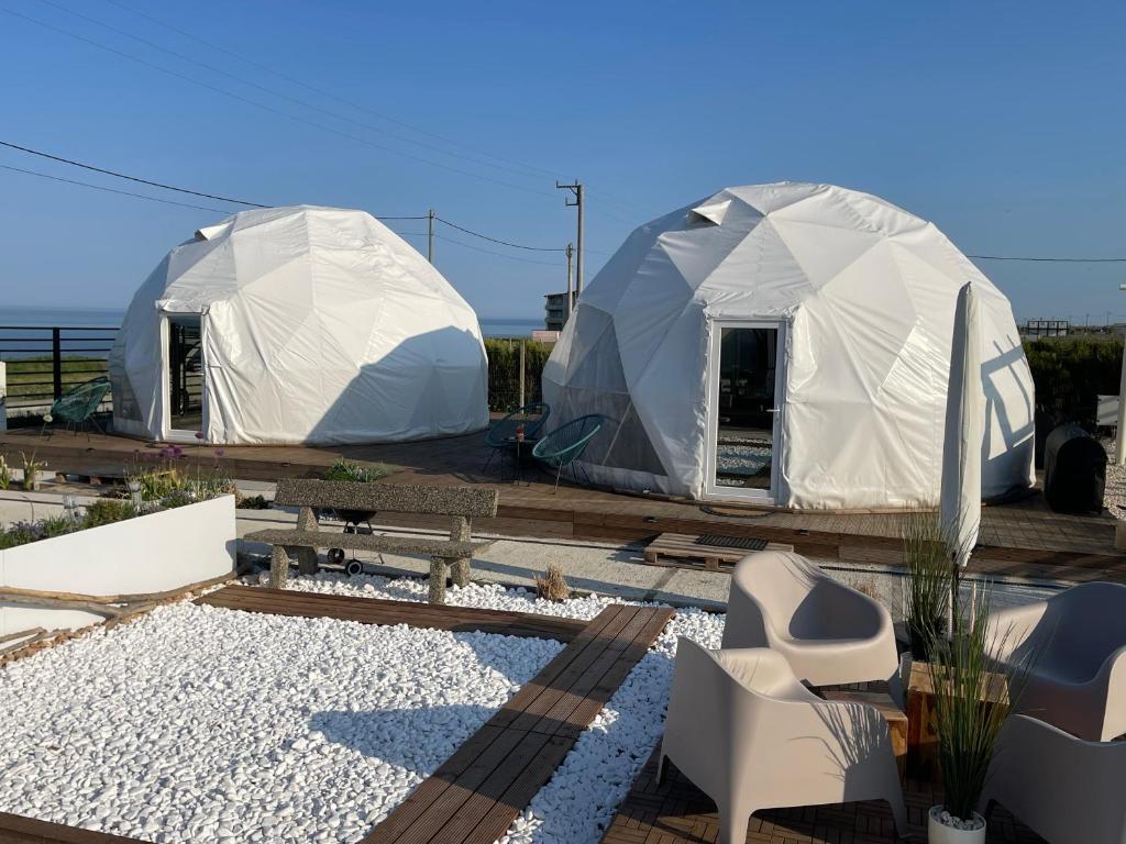 two tents in a yard with a couple of chairs at Maison du golf in Costinesti