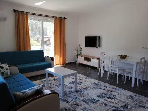 a living room with a blue couch and a table at Olympos Apart in Olympos