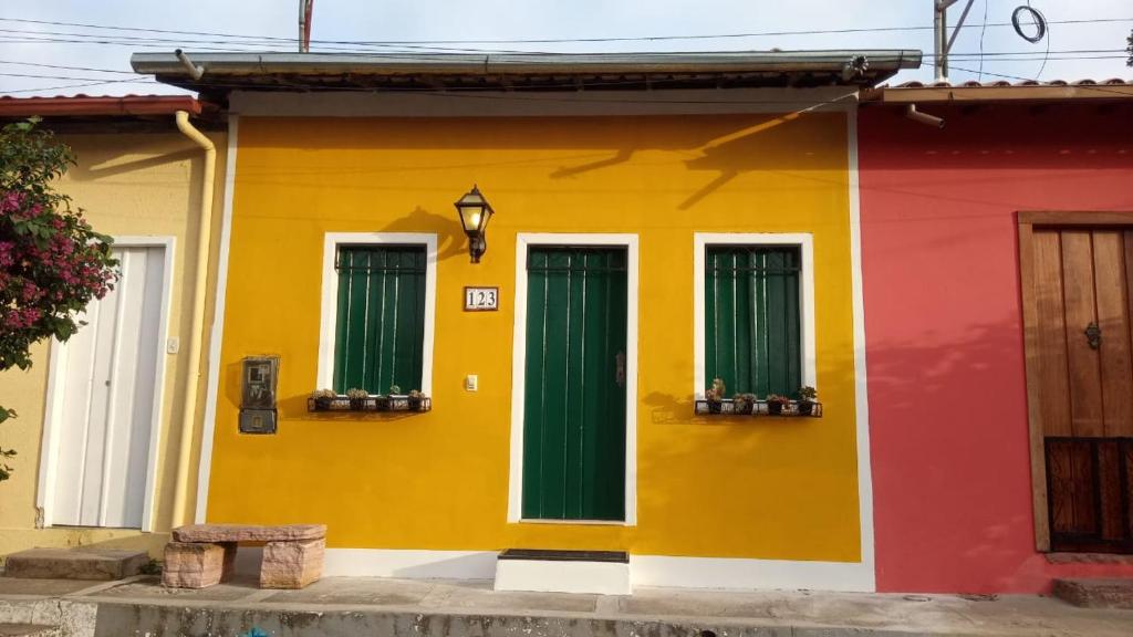 a colorful house with three green doors on it at Garimpo da Terra Suítes in Mucugê