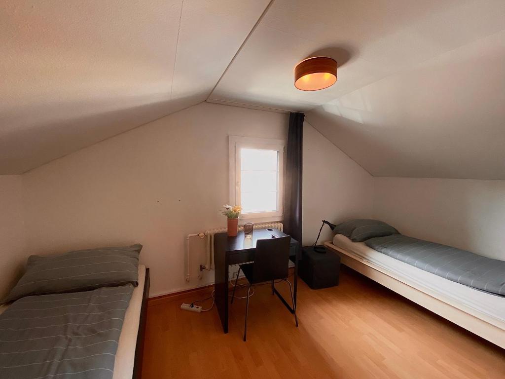 a room with two beds and a desk and a window at Budgetapartment Pfänder von Swisspartments in Arbon