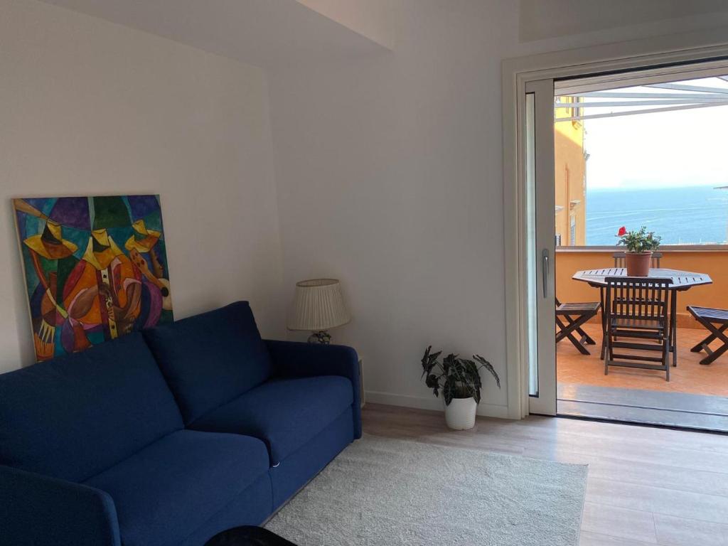 sala de estar con sofá azul y balcón en La casetta en Nápoles