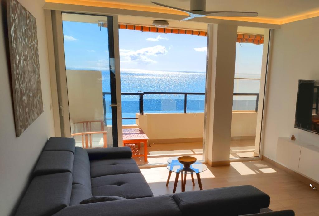 ein Wohnzimmer mit einem Sofa und Meerblick in der Unterkunft BEACHFRONT -- NEW LUXURY Apartment -- 1ª Linea Playa -- Fuengirola CITY CENTER -- Private PARKING -- Panoramic Sea Views -- in Fuengirola