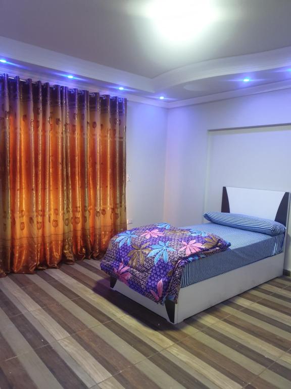 una camera con letto in una stanza con tende di سكن للذكور فقط - Sakan Male Only a Città del 6 ottobre