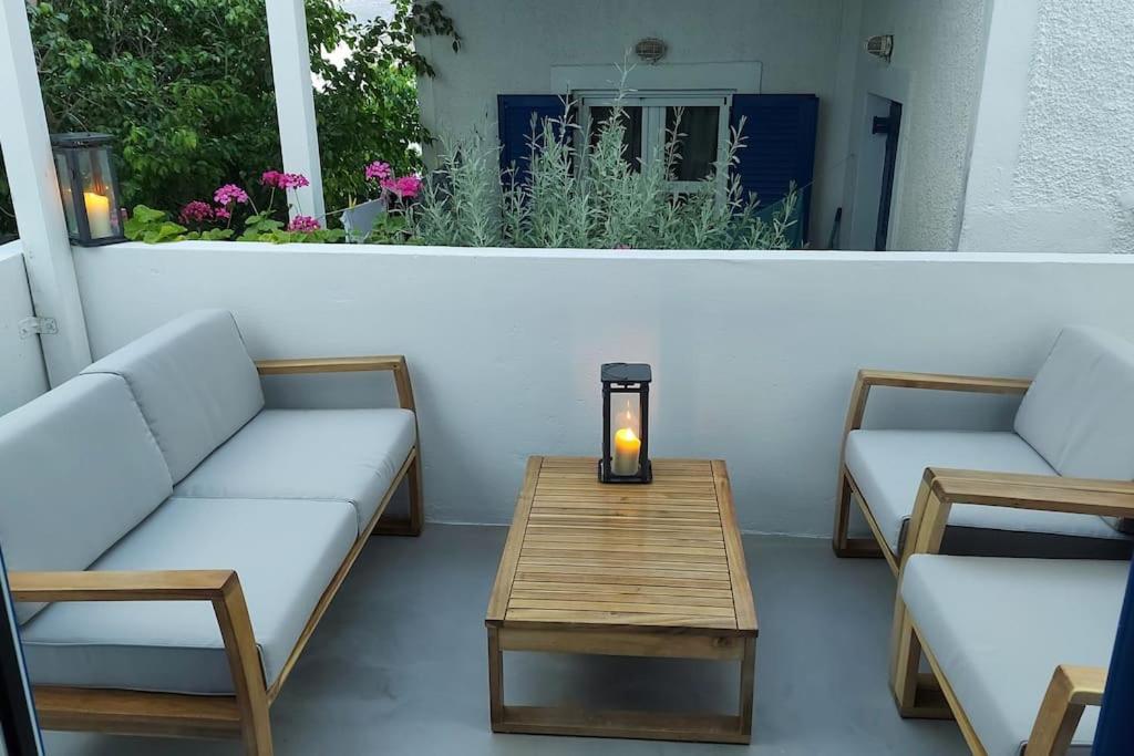 eine Terrasse mit 2 Sofas und einem Tisch mit Kerzen in der Unterkunft Niso in Livadion