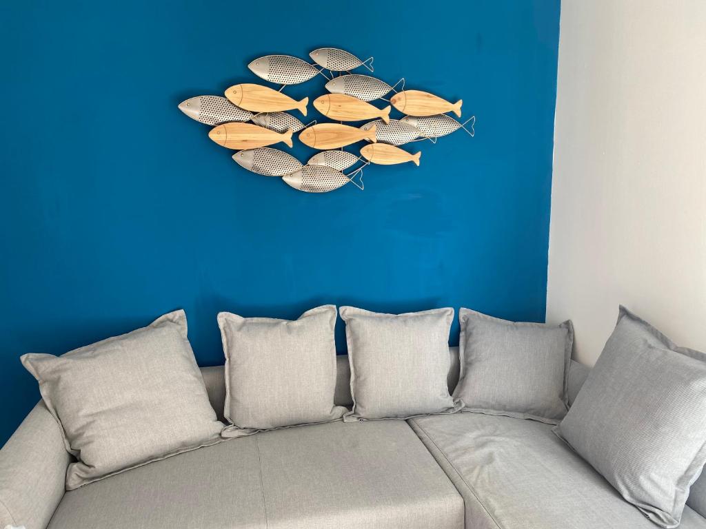 ein Sofa in einem Zimmer mit blauer Wand in der Unterkunft Résidence Fort de l'Eve - 300m plage M Hulot, chemin côtier, commerces - St Marc sur Mer idéal famille proche La Baule Ponichet in Saint-Nazaire
